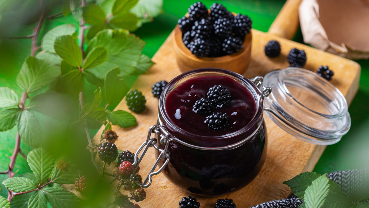 Jar of homemade blackberry jam or confiture with fresh berries. Cooking, preserving at home