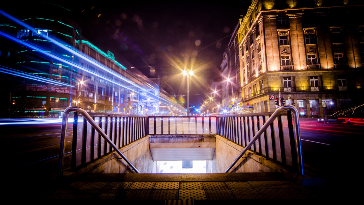 Astoria Square and Hotel with the metro exit in Budapest with vehicles moving with night lights, long shutter speeds, vibrant bright colors, city lights.