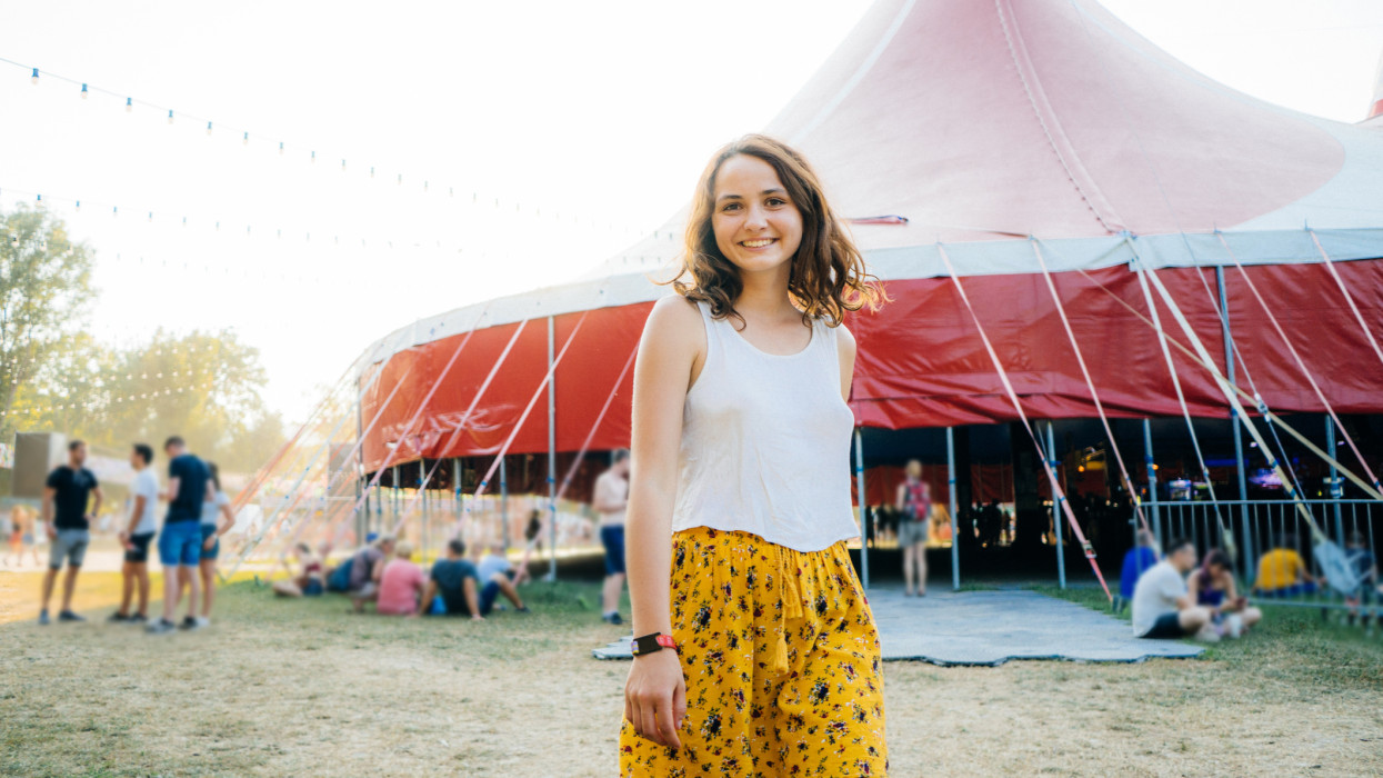 Young Caucasian woman in yellow skirt having fun on music festival in summer