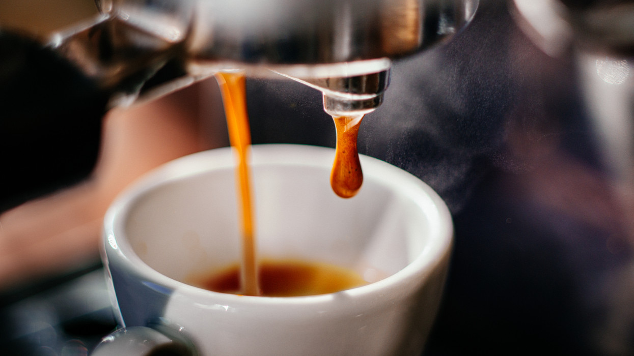 Fresh espresso shot pouring out of machine.