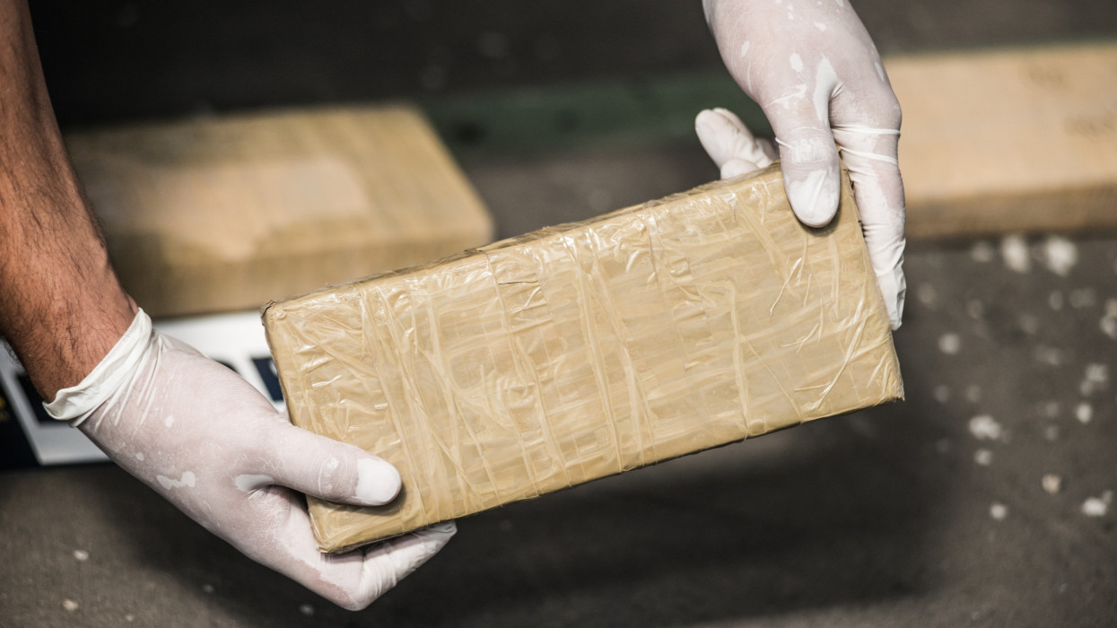 Investigator hands showing a package containing illegal drugs