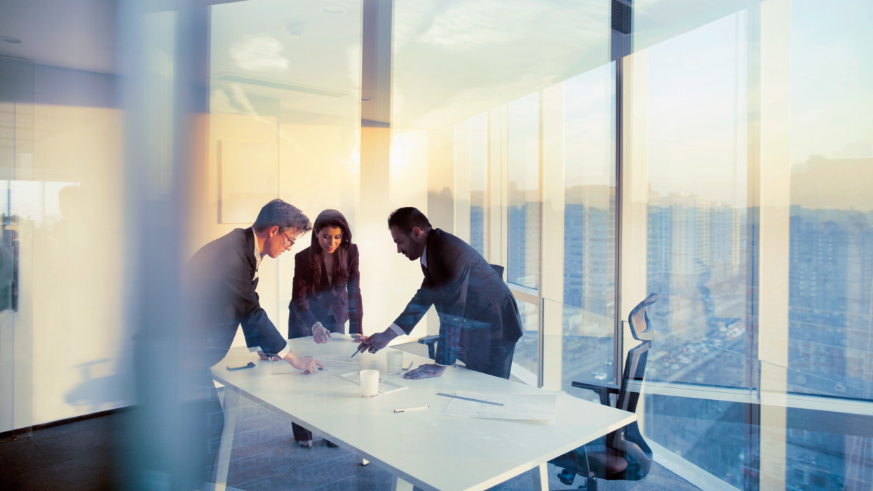 Felnőtt senior sokszínű multietnikus kaukázusi spanyolajkú közel-keleti CEO ügyvezető csapat üzleti emberek együtt konferenciateremben tárgyalóteremben modern modern irodában fényes napsütéses napfény naplemente alkonyat beszélgetés me