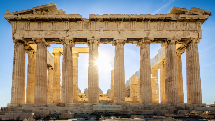 The Parthenon on the Athenian Acropolis, Sun shining through the columns. The Temple is dedicated to the Greek Goddess Athena. Athens, Greece.
