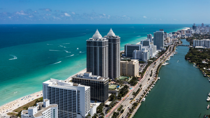 Aerial view of South Beach Miami Florida cityscape with buildings along the beach on a beautiful sunny day, people on beach and ocean, Collins Ave., and Indian Creek