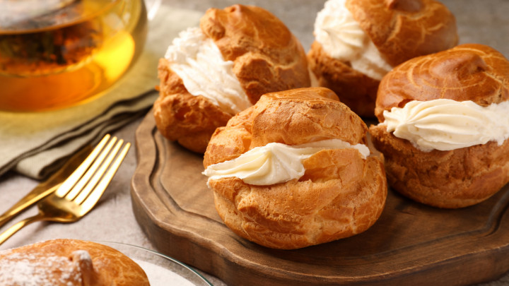 Finom profiteroles krémmel töltött szürke asztalon képviselő fánk