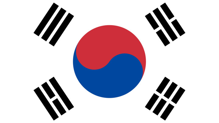Dél-Korea Taegeukgi néven ismert zászlaja történelmi és kulturális jelentőségű szimbólum. Az 1883. augusztus 5-én elfogadott zászló egyedi kialakítású, az ország identitását és értékeit tükröző zászló.A Taegeukgi központi eleme a Taegeuk, a jin és jang elvét jelképező szimbólum, amely a koreai filozófia szerves részét képezi. A Taegeuk két egymást kiegészítő és ellentétes erőre oszlik, egy vörös és egy kék színűre. A felfelé mutató piros rész a pozitív kozmikus erőket jelképezi, míg a lefelé mutató kék rész az ellentétes kozmikus erőket.A Taegeukot négy trigramcsoport, az úgynevezett Kwae veszi körül, amelyek a zászló sarkaiban helyezkednek el. Ezek a trigramok a koreai kultúra különböző természeti elemeit, erényeit és aspektusait jelképezik. A bal felső trigram az eget, a bal alsó trigram a földet, a jobb felső trigram a vizet, a jobb alsó trigram pedig a tüzet jelképezi.A zászló fehér háttere állítólag a tisztaságot és a békét jelképezi. A Taegeuk és a trigramok kombinációja a fehér háttérrel együtt harmonikus kompozíciót alkot, amely az ellentétes erők egyensúlyát és egységét testesíti meg - egy olyan fogalmat, amely mélyen gyökerezik a koreai filozófiában és kultúrában.A Taegeukgi a dél-koreai nép nagy büszkeségének forrása, és különböző alkalmakkor, többek között nemzeti ünnepeken és jelentős eseményeken kerül kiállításra. A Taeggei Taeggei a nemzet identitásának, történelmének és a harmonikus jövőre irányuló törekvéseinek erőteljes szimbólumaként szolgál. A zászló kialakítása tükrözi Dél-Korea tartós értékeit és kulturális örökségét, így az ország jelentőségteljes és ikonikus jelképévé vált.